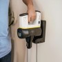 Kärcher Akku-Staubsauger VC 6 Cordless in Ladestation mit Hand am Griff.