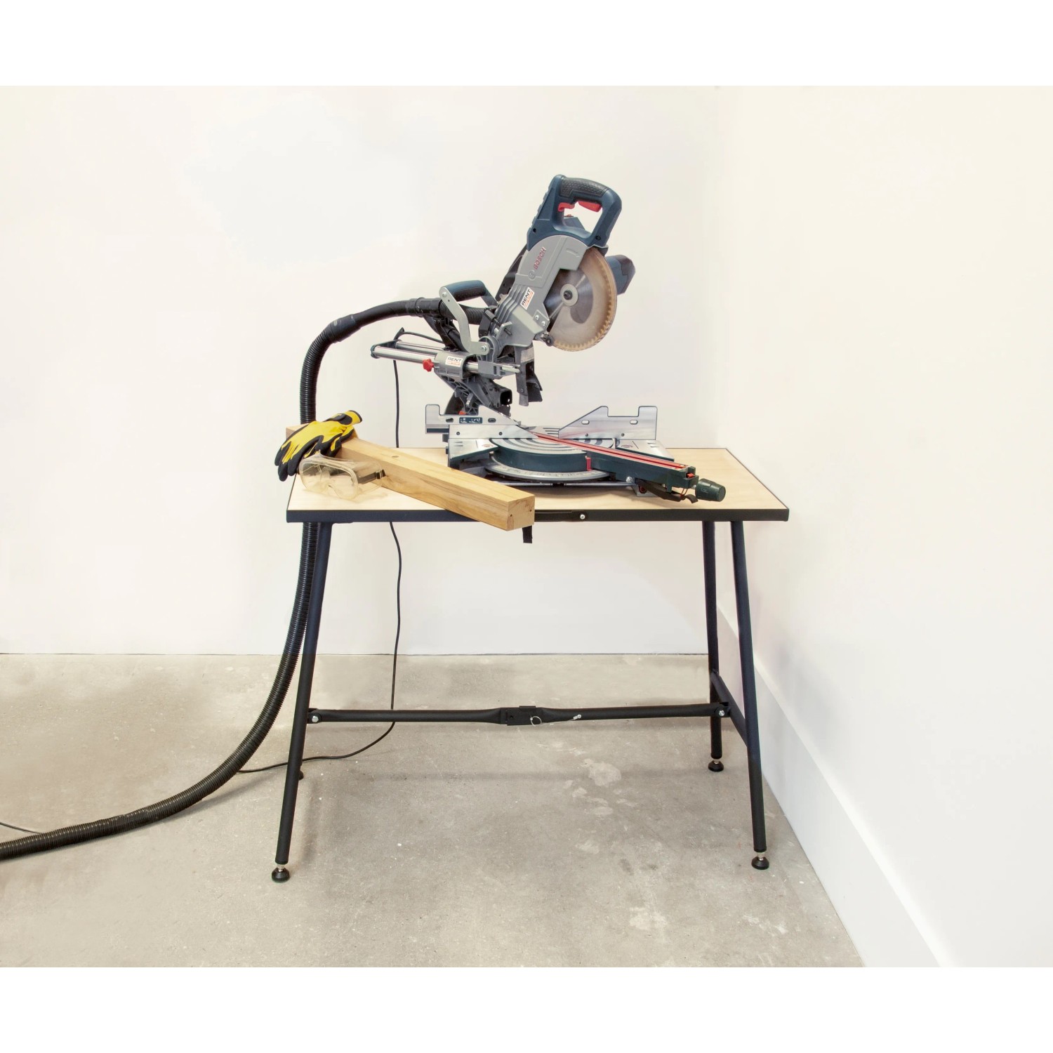 Rikta Klappwerkbank mit montierter Säge, Holz und Handschuhen. Ideal für flexible Arbeitsplätze.
