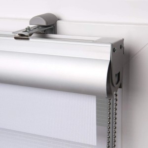 Weißes Sol Royal Doppelrollo mit silberner Alu-Kassette und Klemmfix-Halterung am Fenster. Gestreifter Stoff, Seitenzugkette.