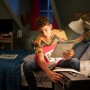 Junge spielt E-Gitarre im Zimmer, beleuchtet mit Philips LED Lampe. Fokus auf entspannte Atmosphäre mit LED-Beleuchtung.