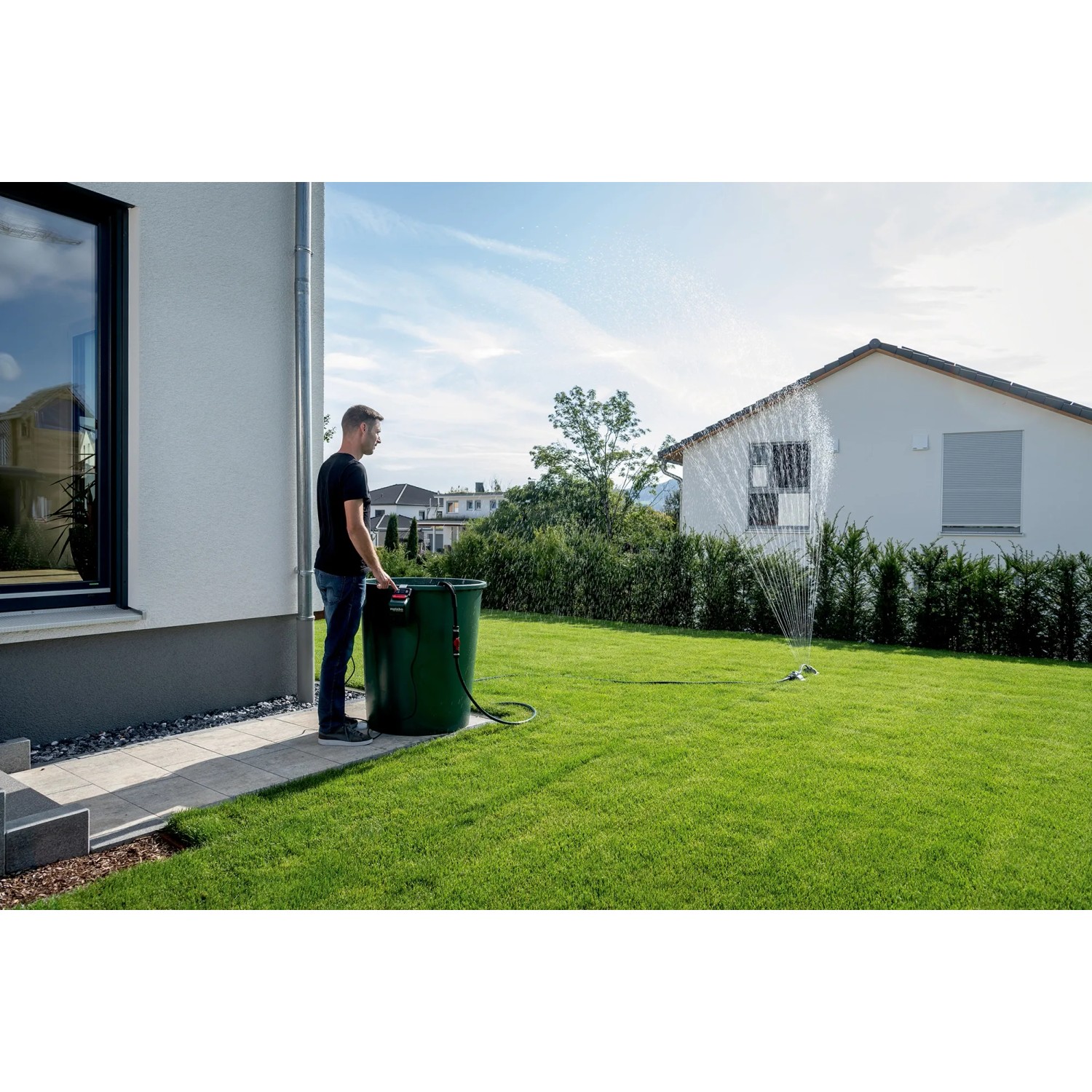 Metabo Akku-Pumpe TPF 18 LTX 2200 beim Bewässern des Gartens mit einem Regner.