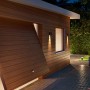 Philips Hue Resonate Außenleuchte, schwarze Wandleuchten strahlen warmweißes Licht nach unten auf eine Holzfassade.