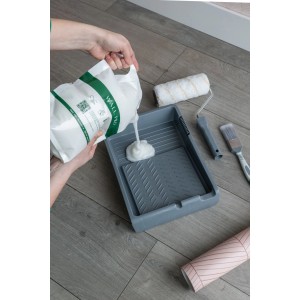 Wallpro Werkzeug-Set für Vliestapeten: Kleister wird in eine Farbwanne gegossen, mit Rolle und Pinsel.