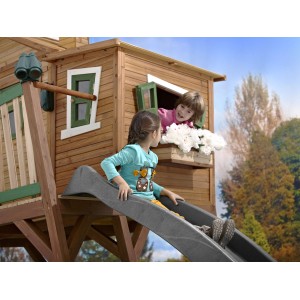 Axi Max Spielhaus mit Rutsche, Kinder spielen im braun-grünen Holzhaus mit grauer Rutsche.
