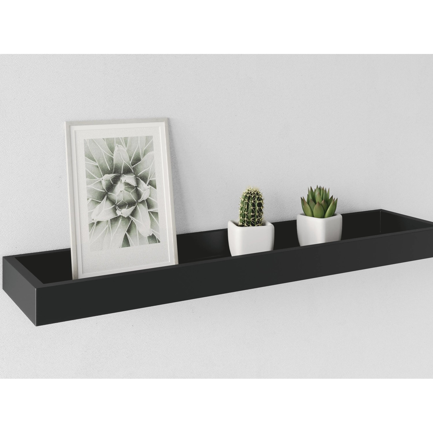 Schwarze Fotoleiste Bix (40x15x4 cm) an der Wand mit Bilderrahmen und kleinen Kakteen.