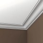 Weiße PROFHOME Eckleisten als Deckenabschluss in einem Raum mit brauner Wand.