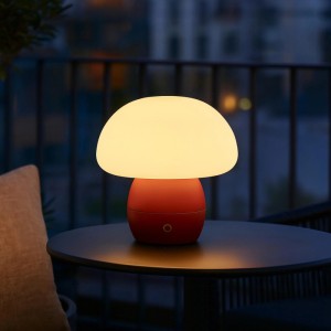 Rote LED-Tischleuchte Dupos in Pilzform leuchtet warm auf dunklem Balkontisch. Modernes Design, dimmbar.