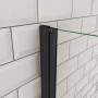 Detailaufnahme: Schwarze AICA Walk-In Duschabtrennung mit Falttür vor weißer Wand.