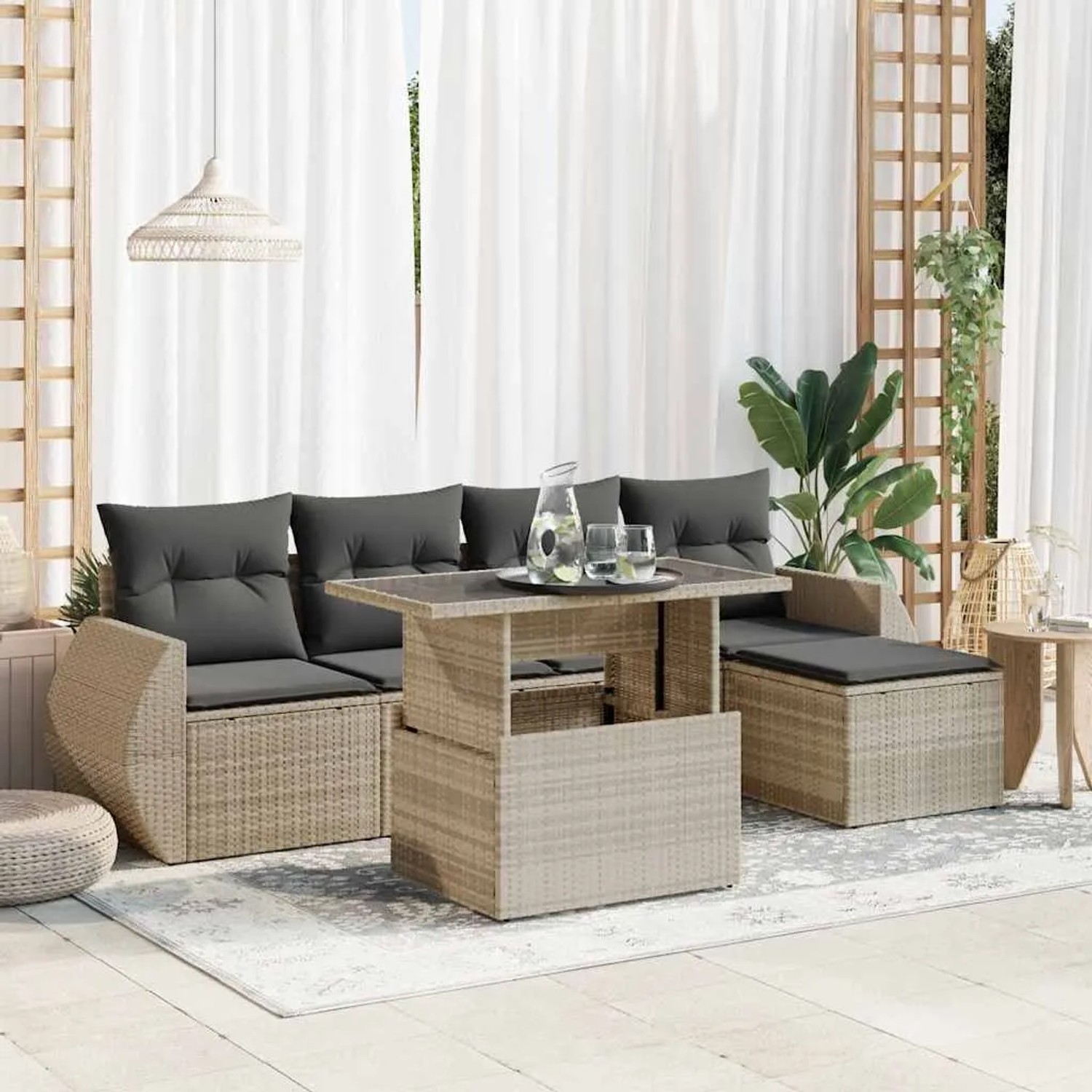 Hellgraue 6-tlg. Rattan Garten-Sofagarnitur mit Tisch, Hockern und grauen Kissen.