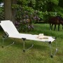 XXL Sonnenliege Abaco in Silber-Beige mit Hut und Buch im Garten.