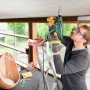 Mann bohrt mit Bosch Bohrhammer PBH 2500 SRE in Decke. Bohrmaschine für Beton.