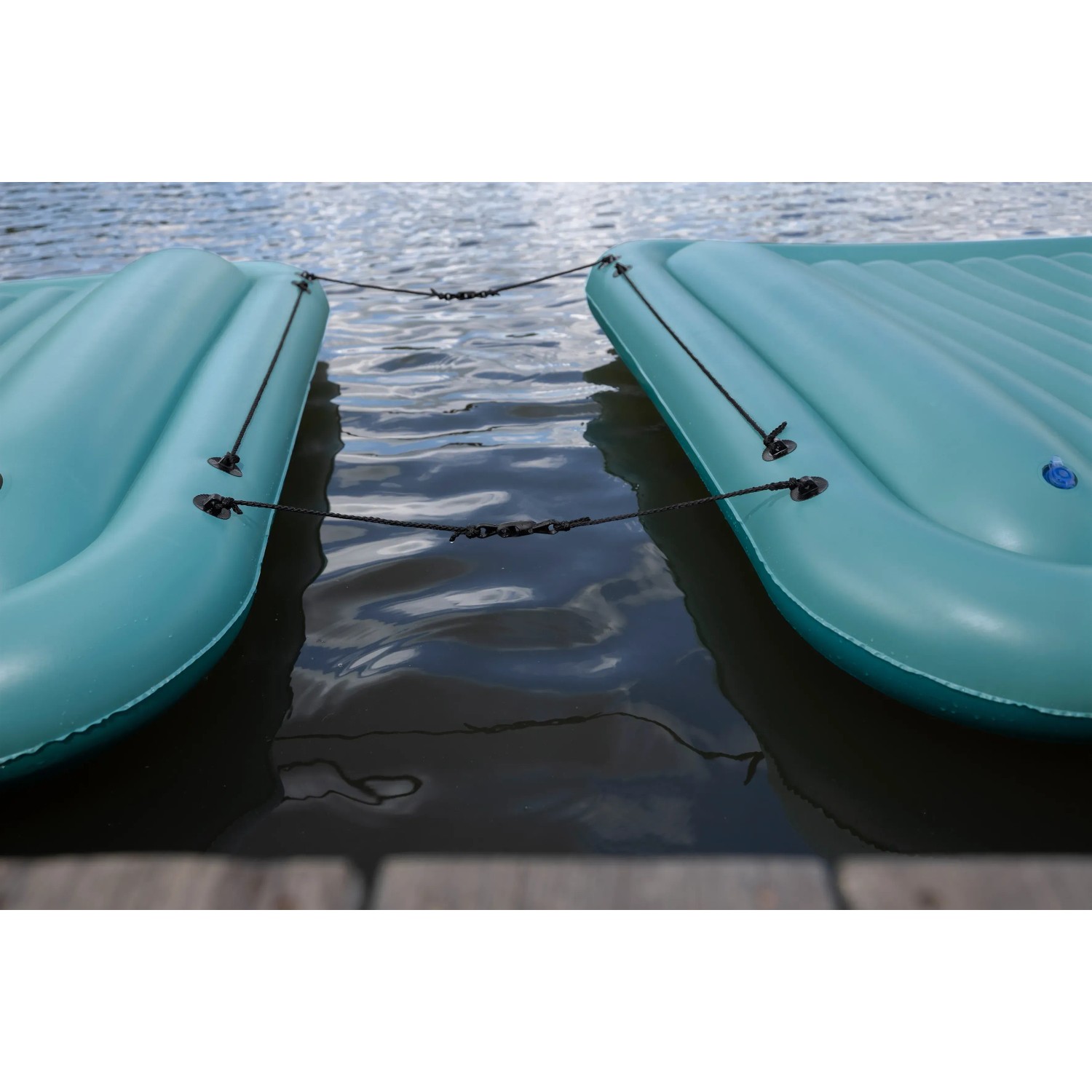 Zwei verbundene, türkisfarbene Bestway Hydro Force Floating Platforms auf dem Wasser.