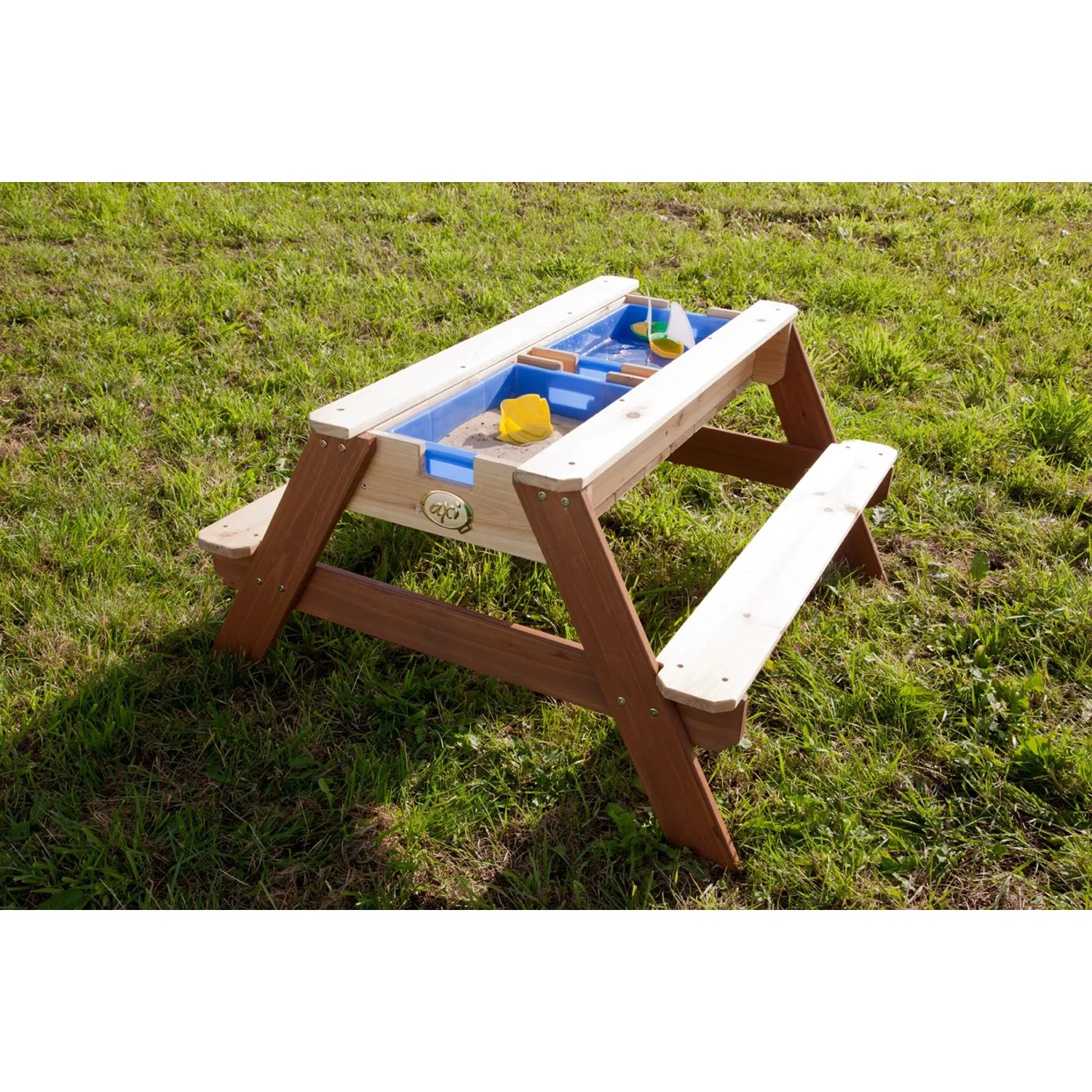 Sand- und Wasserspieltisch Nick Braun aus Holz mit blauen Wannen und Spielzeug auf Rasen.