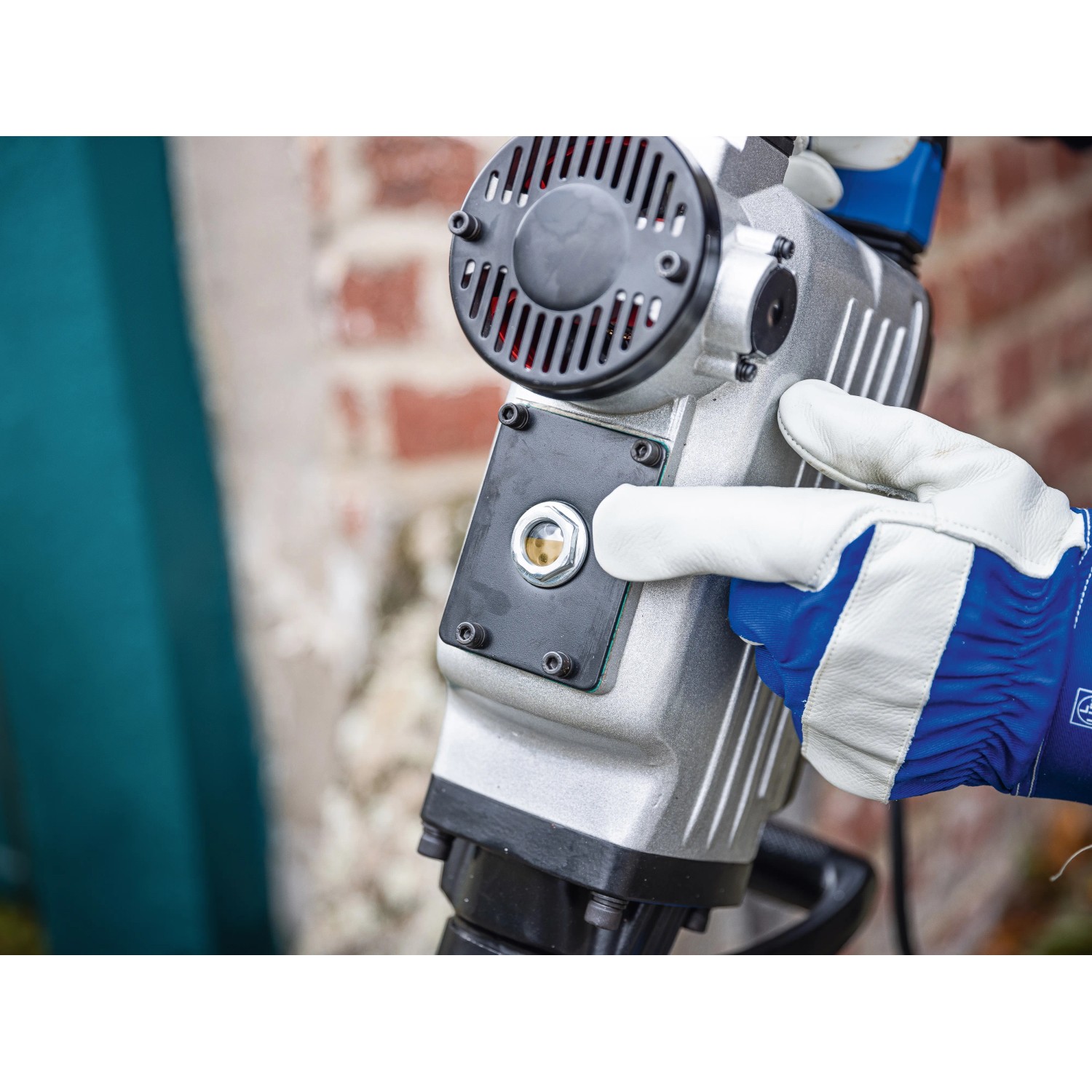 Nahaufnahme des LUX Abbruchhammers E-AHM-1700, Baumaschine mit Hand in Arbeitshandschuh.