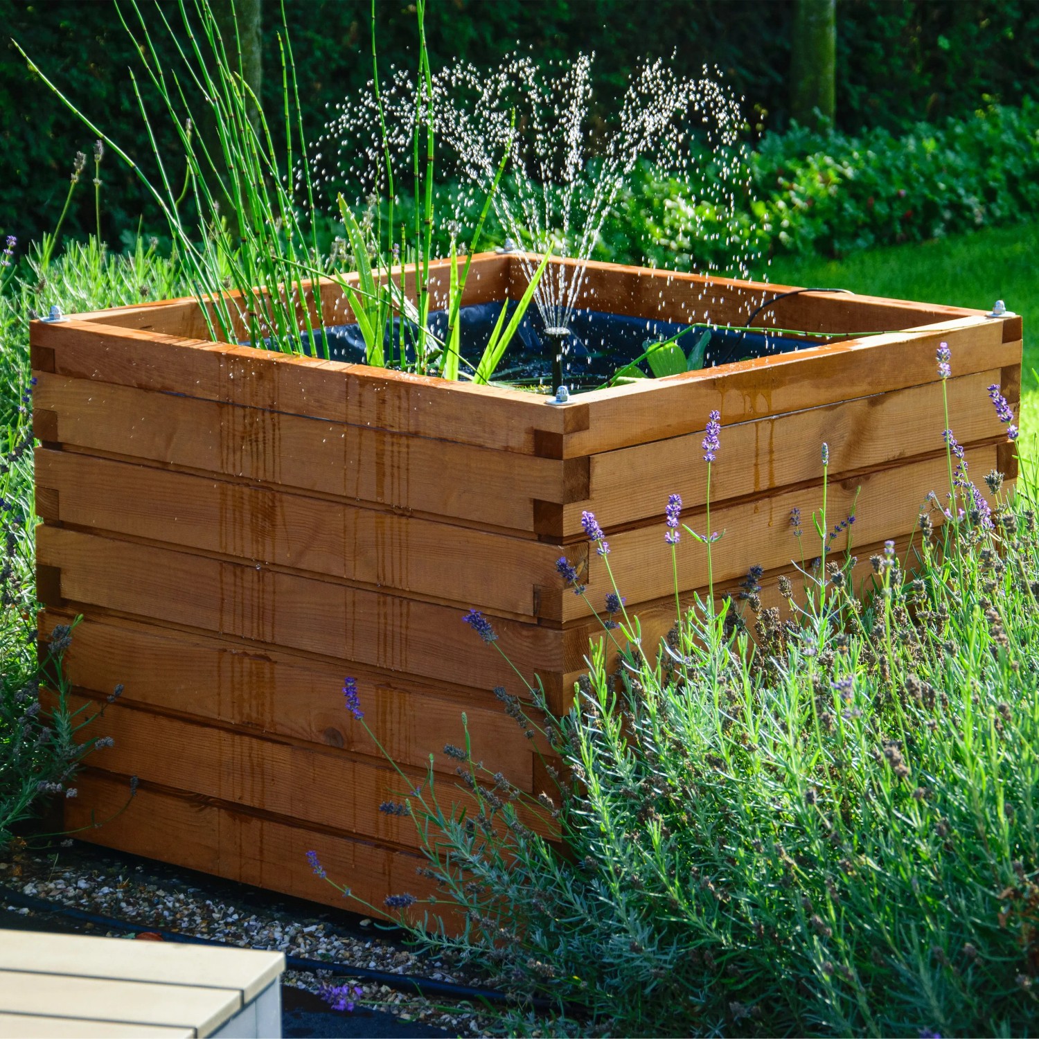 Quadratischer Dobar Gartenteich Alea aus Kiefernholz mit Teichfolie und kleiner Fontäne im Garten.