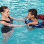 Kind mit Bestway Schwimmring Spider-Man (Ø 48 cm) im Pool mit Aufsichtsperson.
