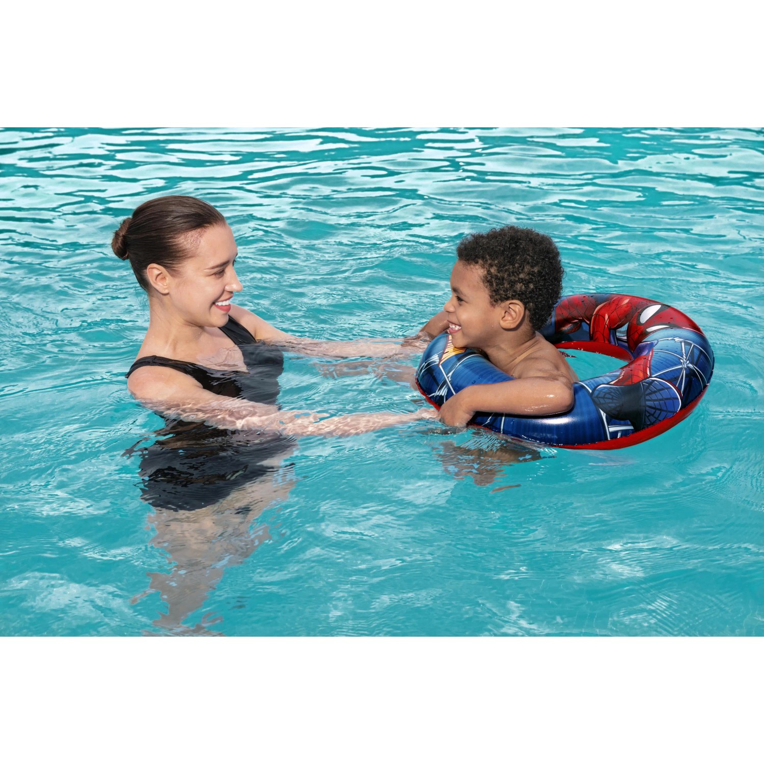 Kind mit Bestway Schwimmring Spider-Man (Ø 48 cm) im Pool mit Aufsichtsperson.