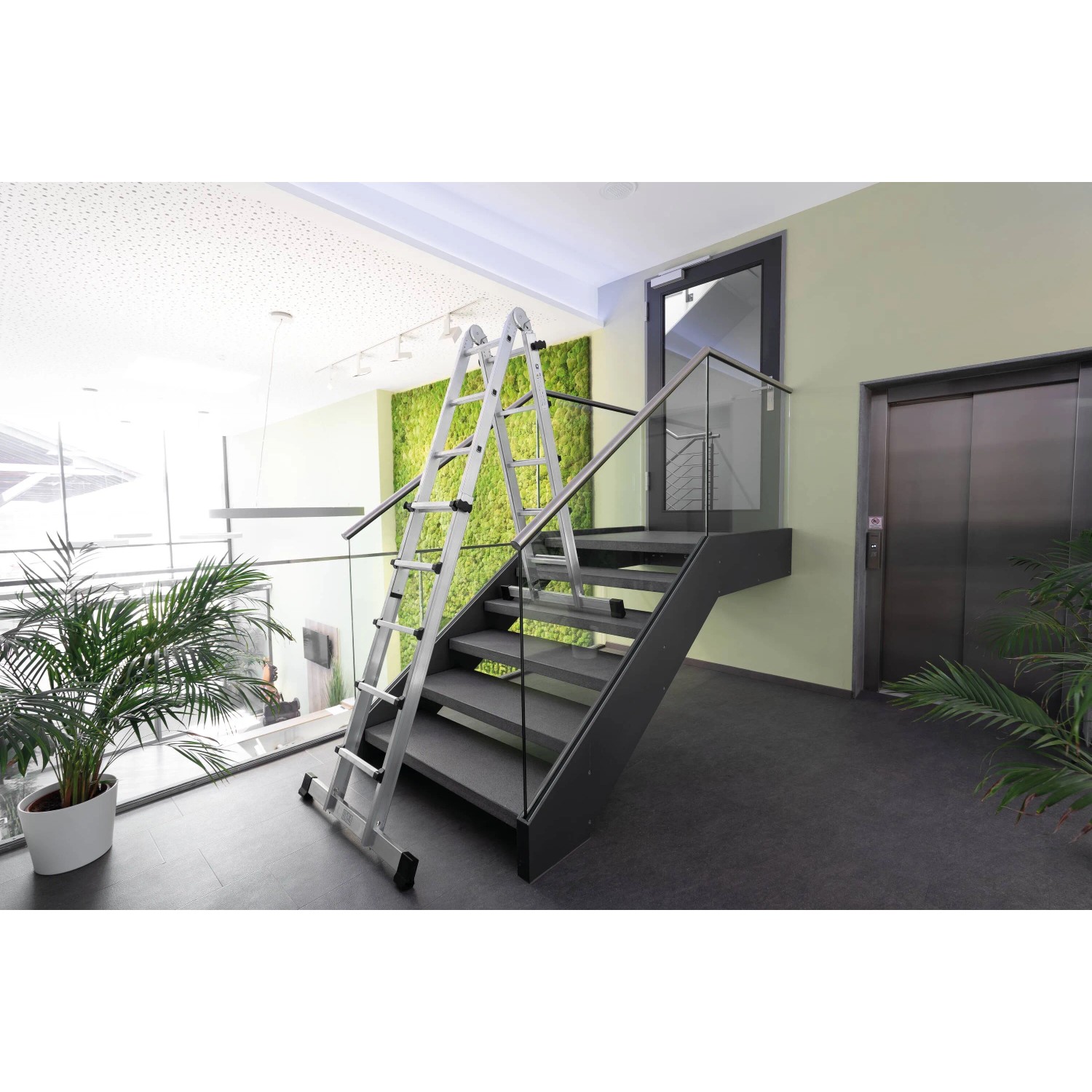 PROREGAL Teleskopleiter, 4-teilig, mit Traverse, 4x6 Sprossen, aus Aluminium, auf einer Treppe.