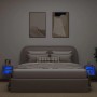 Zwei betongraue TV-Wandschränke mit LED-Beleuchtung neben einem Bett.