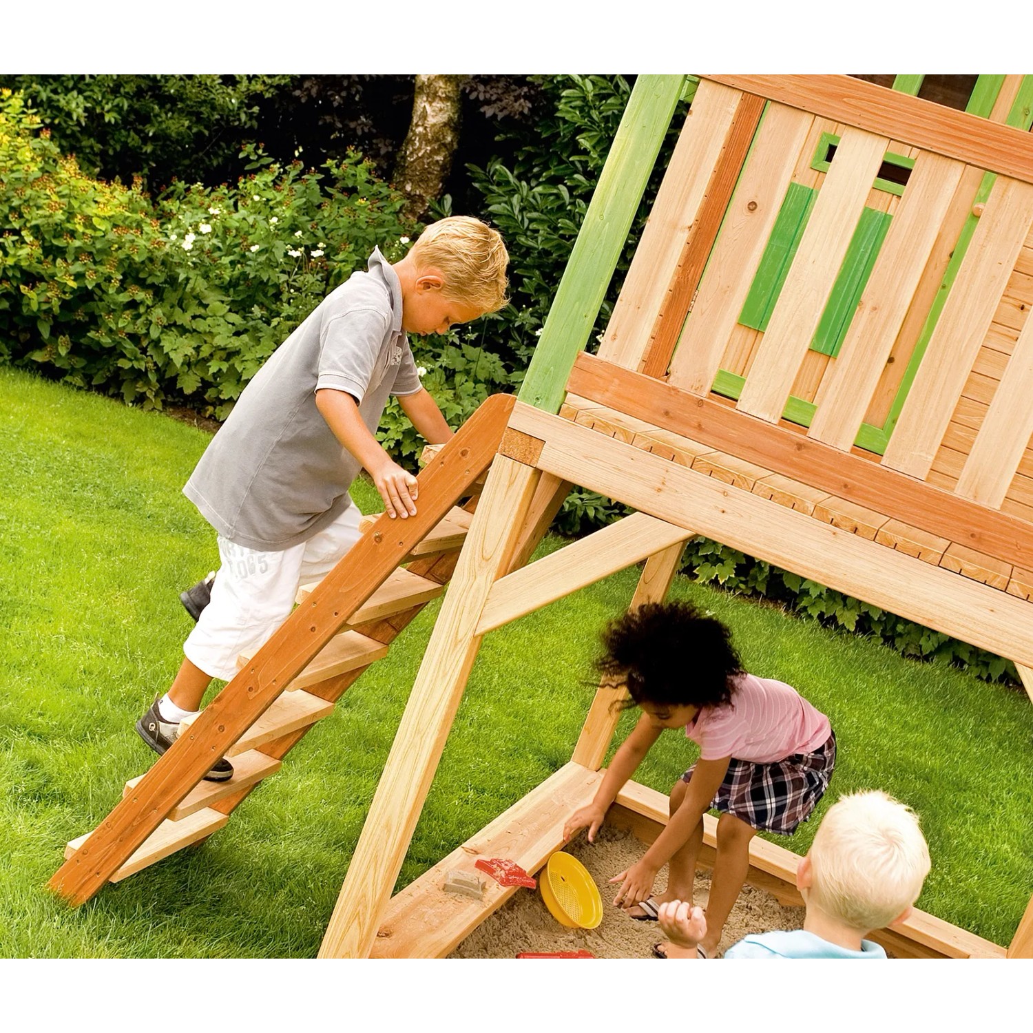 Axi Sarah Spielhaus aus Holz mit Rutsche und Sandkasten, Kinder spielen.