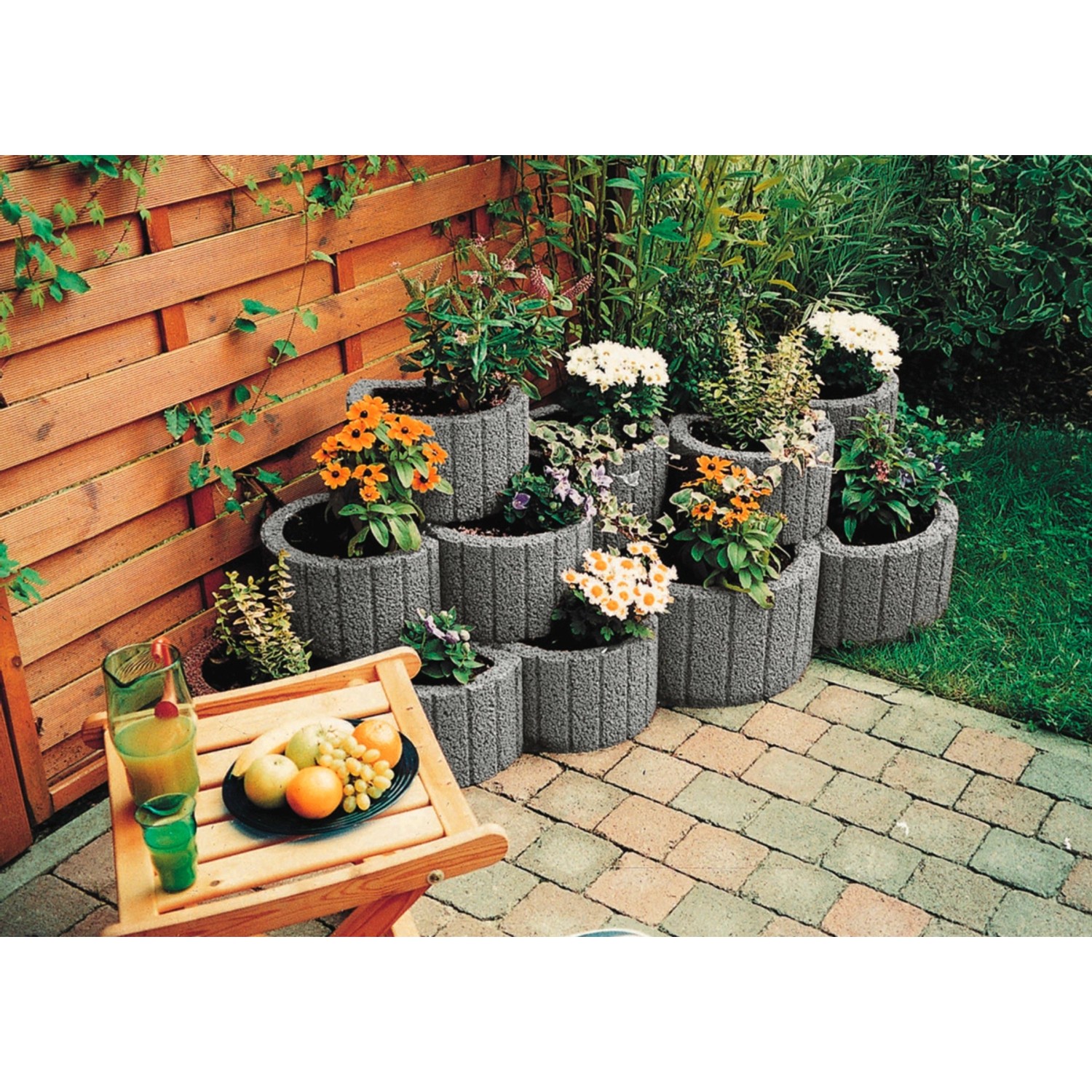 Gestapelte graue Pflanzringe Klein 35 cm x 20 cm mit Bepflanzung als Hangsicherung.