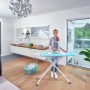 Frau bügelt Wäsche auf dem Leifheit AirBoard Compact M Plus Bügeltisch mit Thermo-Reflect Bezug.