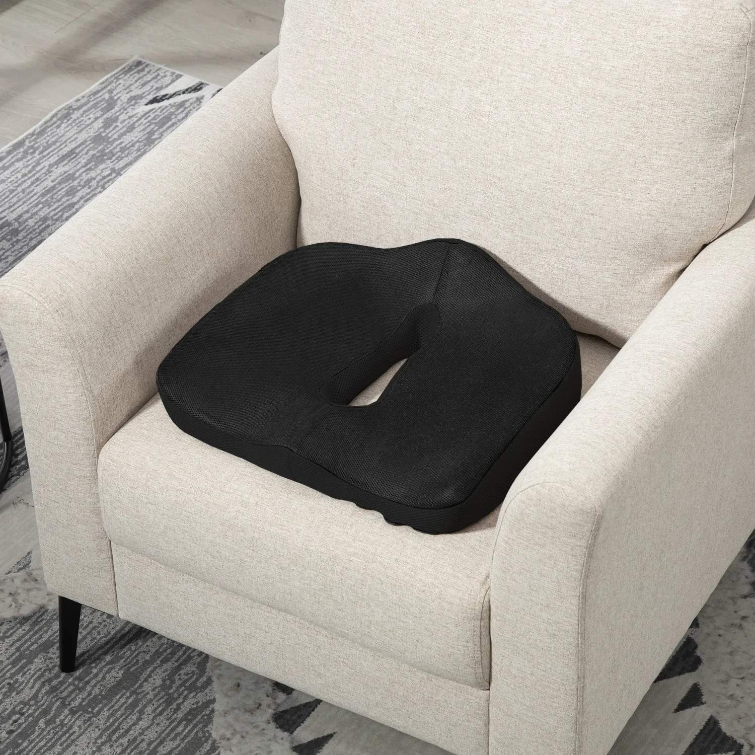 Schwarzes, orthopädisches HOMCOM Sitzkissen aus Polyester auf einem Sessel. 44x39x13cm.