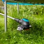 Gardena EasyCut 450/25 Elektro-Rasentrimmer trimmt Gras präzise um einen Pfosten. Schwarz-türkiser Kopf für Kanten.
