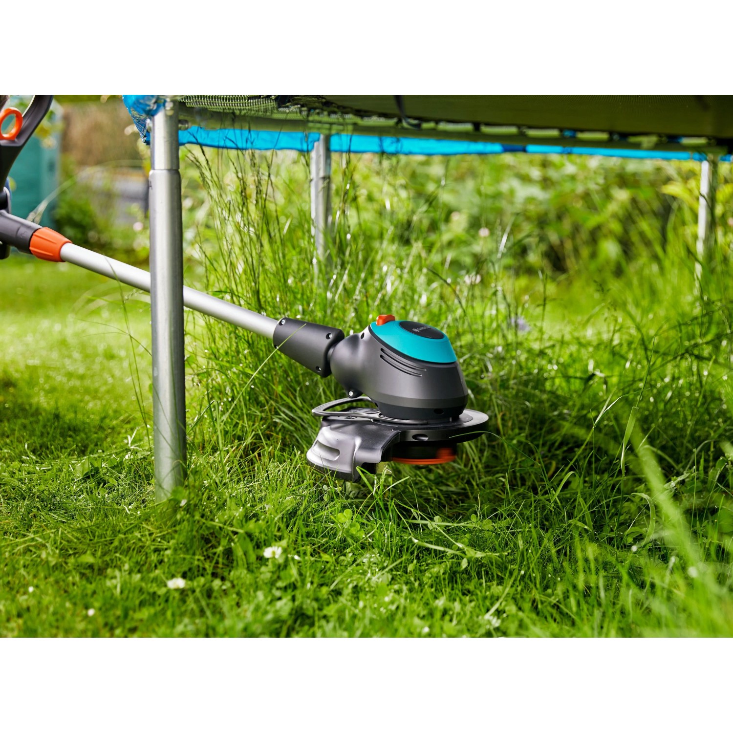 Gardena EasyCut 450/25 Elektro-Rasentrimmer trimmt Gras präzise um einen Pfosten. Schwarz-türkiser Kopf für Kanten.