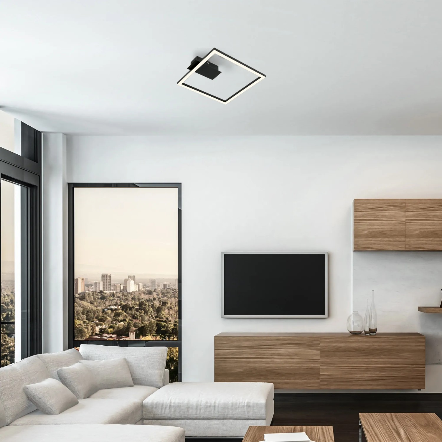 Moderne, schwarze LED-Deckenleuchte Nici mit warmweißem Licht im Wohnzimmer.