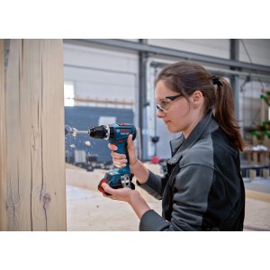 Frau bohrt mit Bosch Professional Akku-Schlagbohrschrauber GSB 18V-90 C in Holz.