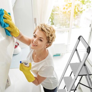 Frau putzt mit Alu-Klappleiter von Mephisto (4 Stufen) die Küche. Haushaltsleiter mit Bügel für sicheren Stand.