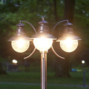 Rustikale, braune Lindby Mastleuchte Eddie mit drei Leuchten für den Außenbereich.