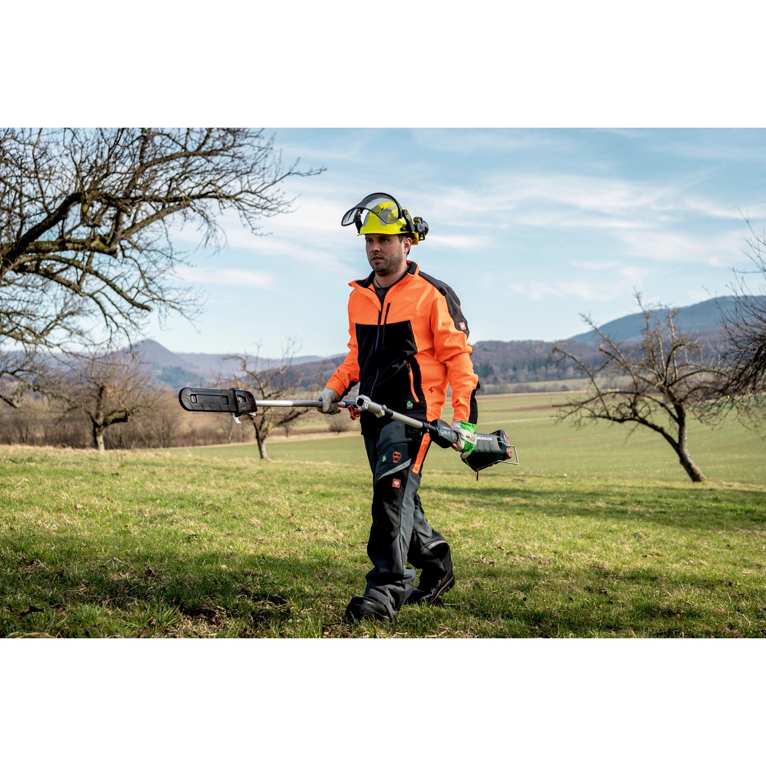Mann mit Metabo Hochentaster-Aufsatz MA-MS 25 im Garten. Akku-Heckenschere für Baumpflege.