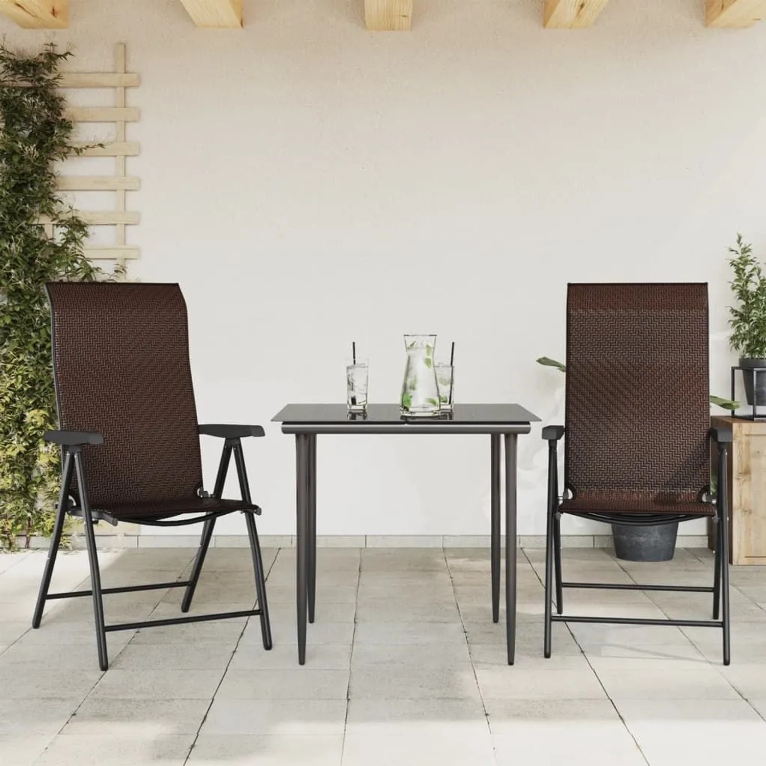 Zwei braune klappbare Poly Rattan Gartenstühle mit schwarzem Stahlrahmen auf einer Terrasse, mit Tisch.
