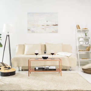 Relaxdays Beistelltisch aus Walnussholz mit Glasplatte und 2 Ablagen im Wohnzimmer, dekoriert mit Wein und Büchern.