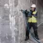 Handwerker mit Bosch Akku-Schlaghammer GSH 18V-5 beim Stemmen einer Wand.
