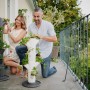 Gusta Garden Erdbeerturm Sissi anthrazit mit Personen beim Bepflanzen auf Balkon.