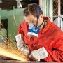 Mann mit Dräger X-plore 4740 Halbmaske, Schutzbrille und Handschuhen schleift Metall. Atemschutz für Industrie & Handwerk.