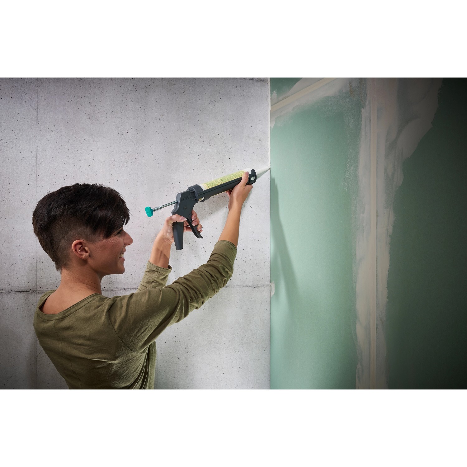 Frau benutzt wolfcraft Kartuschenpresse MG 100 für Silikon/Acryl an Wand. Maurerwerkzeug mit Tropf-Stopp.