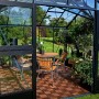 Juliana Gewächshaus Orangerie 15, schwarz-anthrazit, mit Sitzgruppe und Pflanzen.