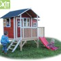 Rotes EXIT Loft 350 Holzspielhaus mit Rutsche und Kindern im Garten.