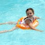 Mädchen schwimmt mit orangefarbenem Freds Swim Academy Schwimmreifen im Pool.