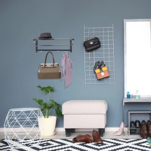 Schwarze Relaxdays Wandgarderobe aus Stahl mit Ablage und 4 silbernen Haken. Hut, Tasche und Schal hängen im modernen Flur.