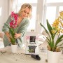Frau pflanzt Orchidee mit Lechuza Orchidpon Substrat. Spezialerde für gesundes Wachstum und üppige Blüten.