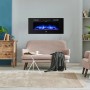 El Fuego Elektrokamin Bern 130 mit LED-Ambientelicht (blau) an Wand über Sofa.