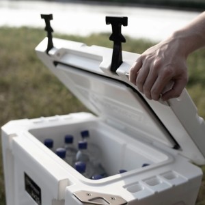 Geöffnete, alpenweiße Petromax Kühlbox (25 l) mit Wasserflaschen. Hand öffnet den Deckel.
