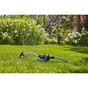 Gardena EcoLine Viereckregner bewässert Rasenfläche. Regner mit Wasserstrahlen im Garten.