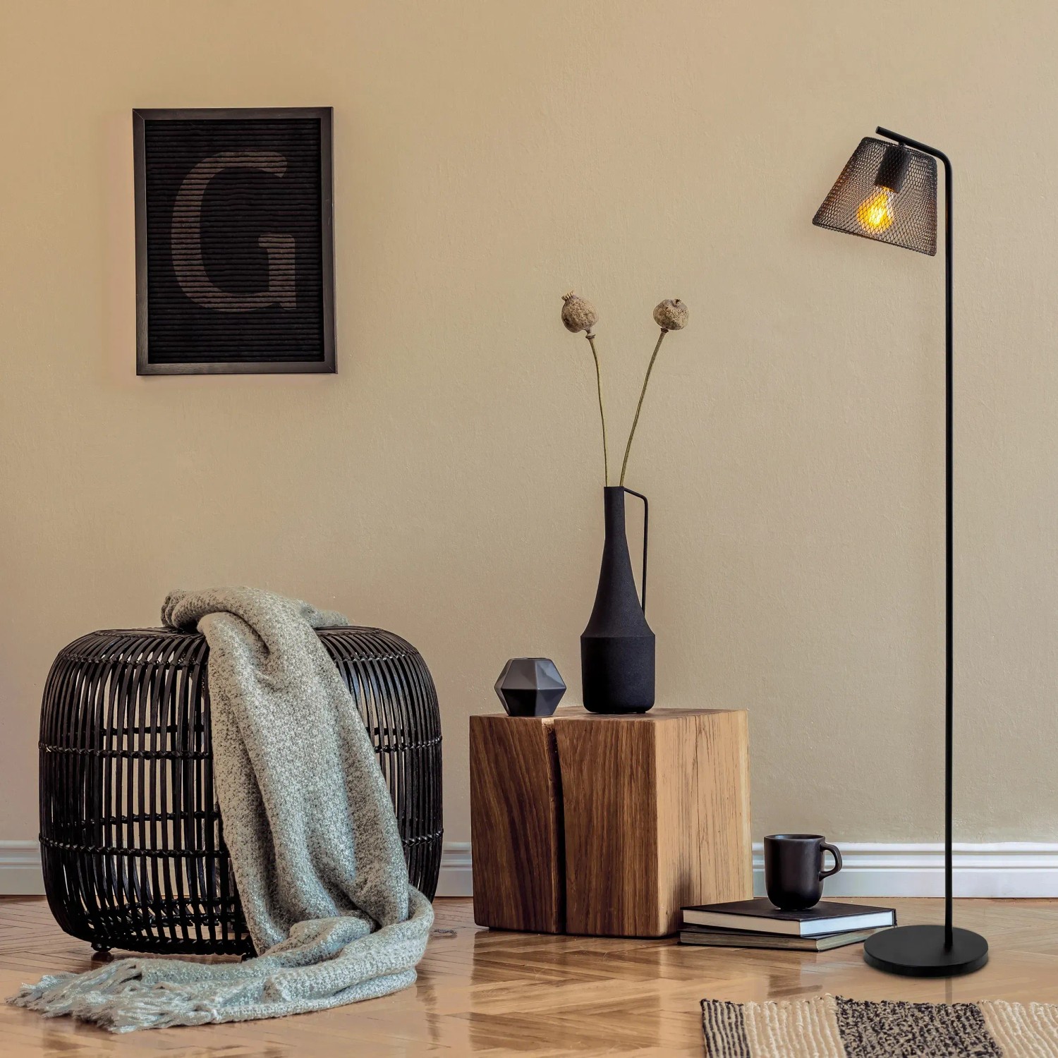 Schwarze Näve Stehleuchte Korie, 140 cm, im Wohnraum mit Gitterdesign und warmem Licht.