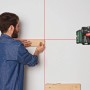 Bosch Quigo Kreuzlinienlaser mit MM 2 Universalklemme im Einsatz beim Ausrichten.